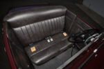 10 1932 Ford Roadster cockpit showcasing a classic black banjo steering wheel and tuck and roll leather bench seat