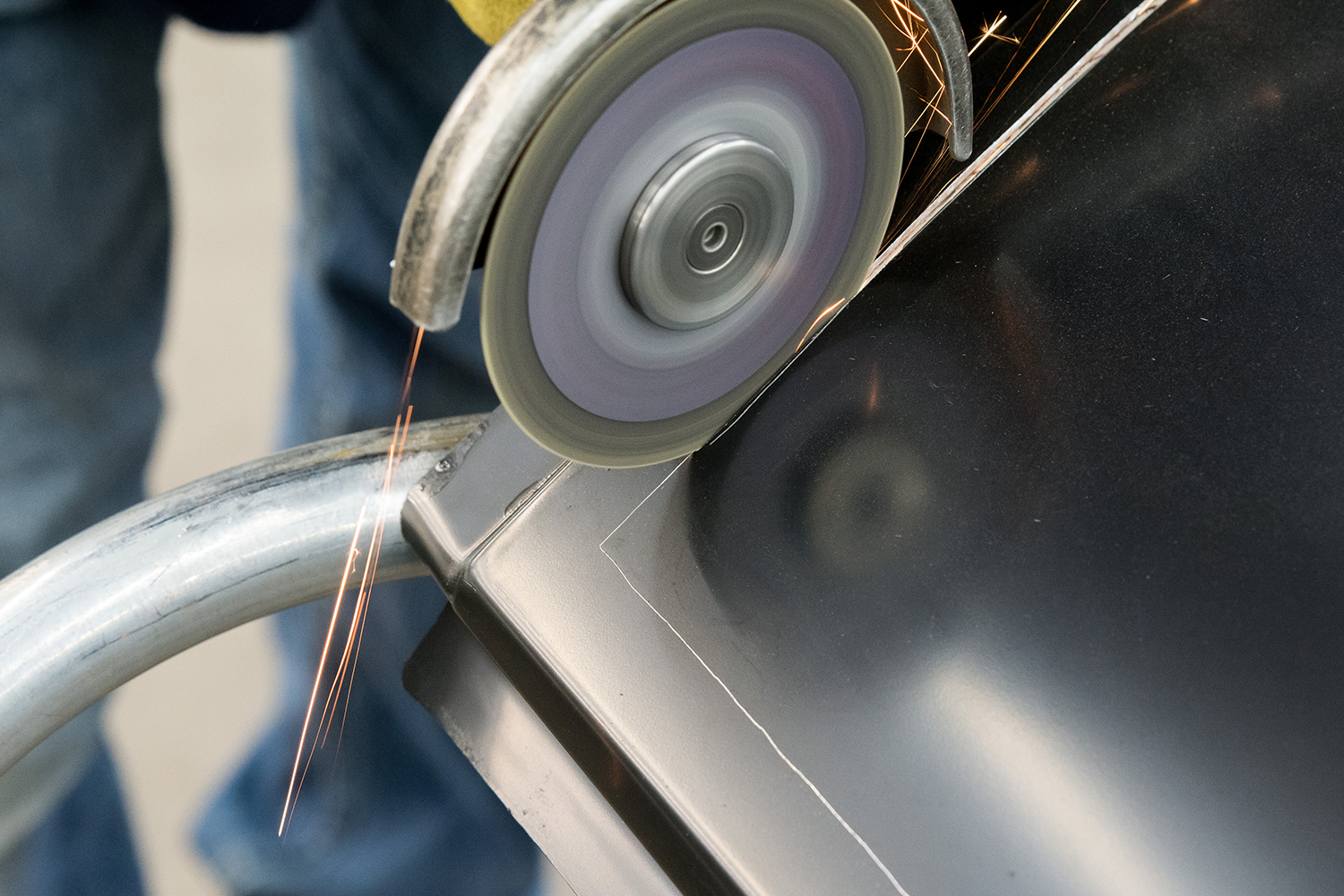 10 technician using a cutoff wheel to trim the new quarter panel for precise fitment