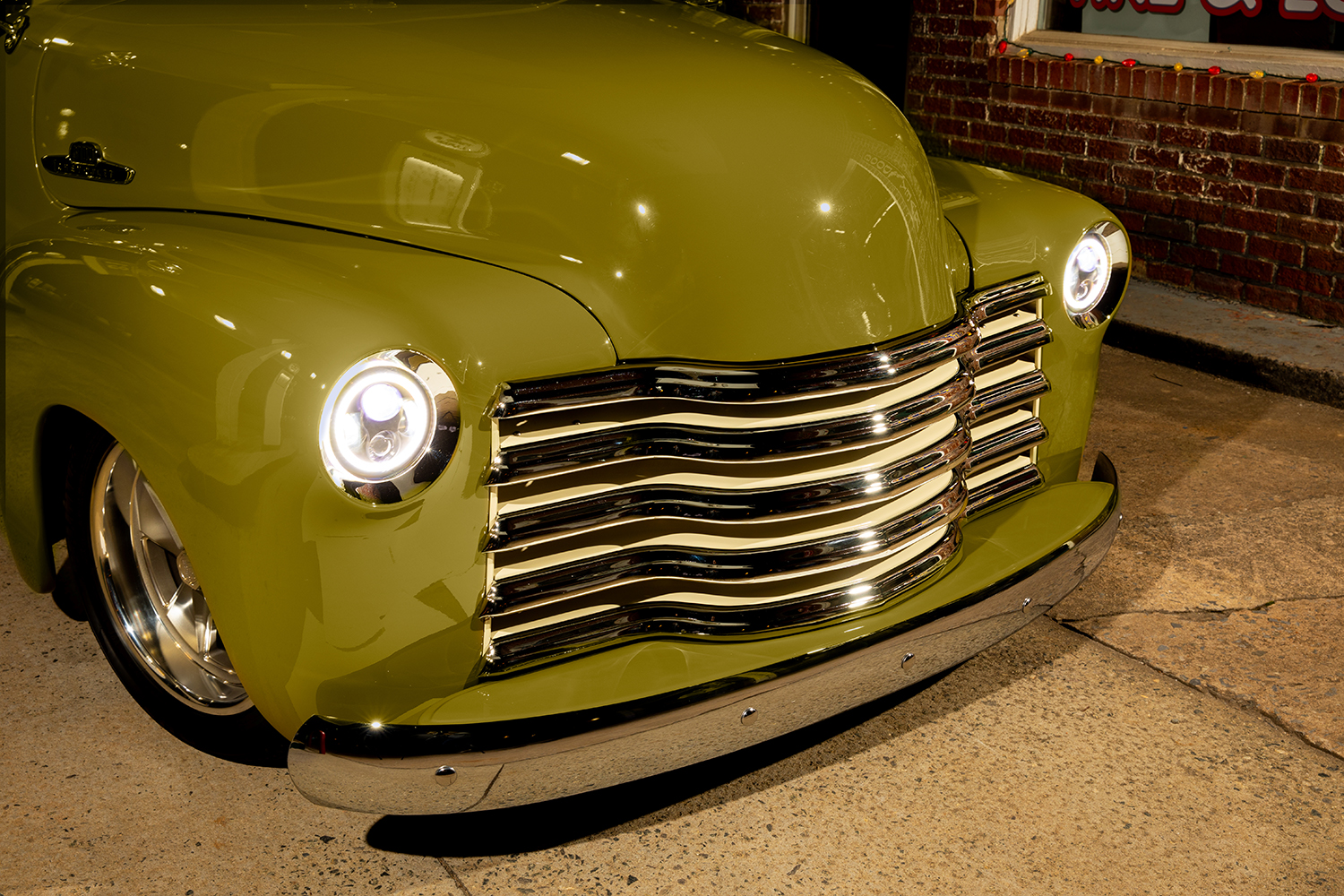 13 1952 Chevrolet 3100 front end with a chrome five bar grille LED halo headlights and flawless olive green paint