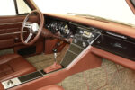 13 1963 Buick Riviera interior with brown leather a chrome accented dash and a classic style radio