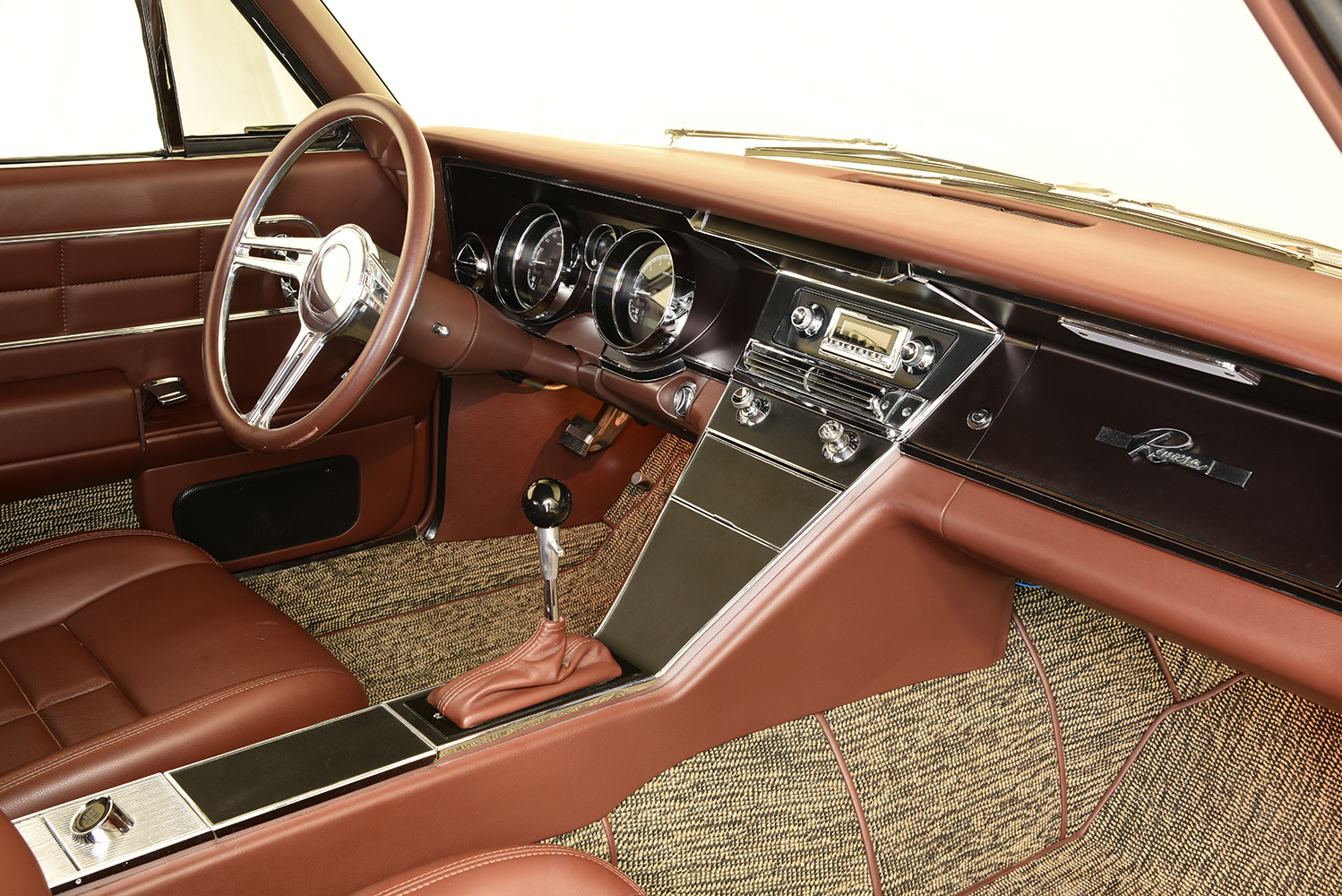 13 1963 Buick Riviera interior with brown leather a chrome accented dash and a classic style radio
