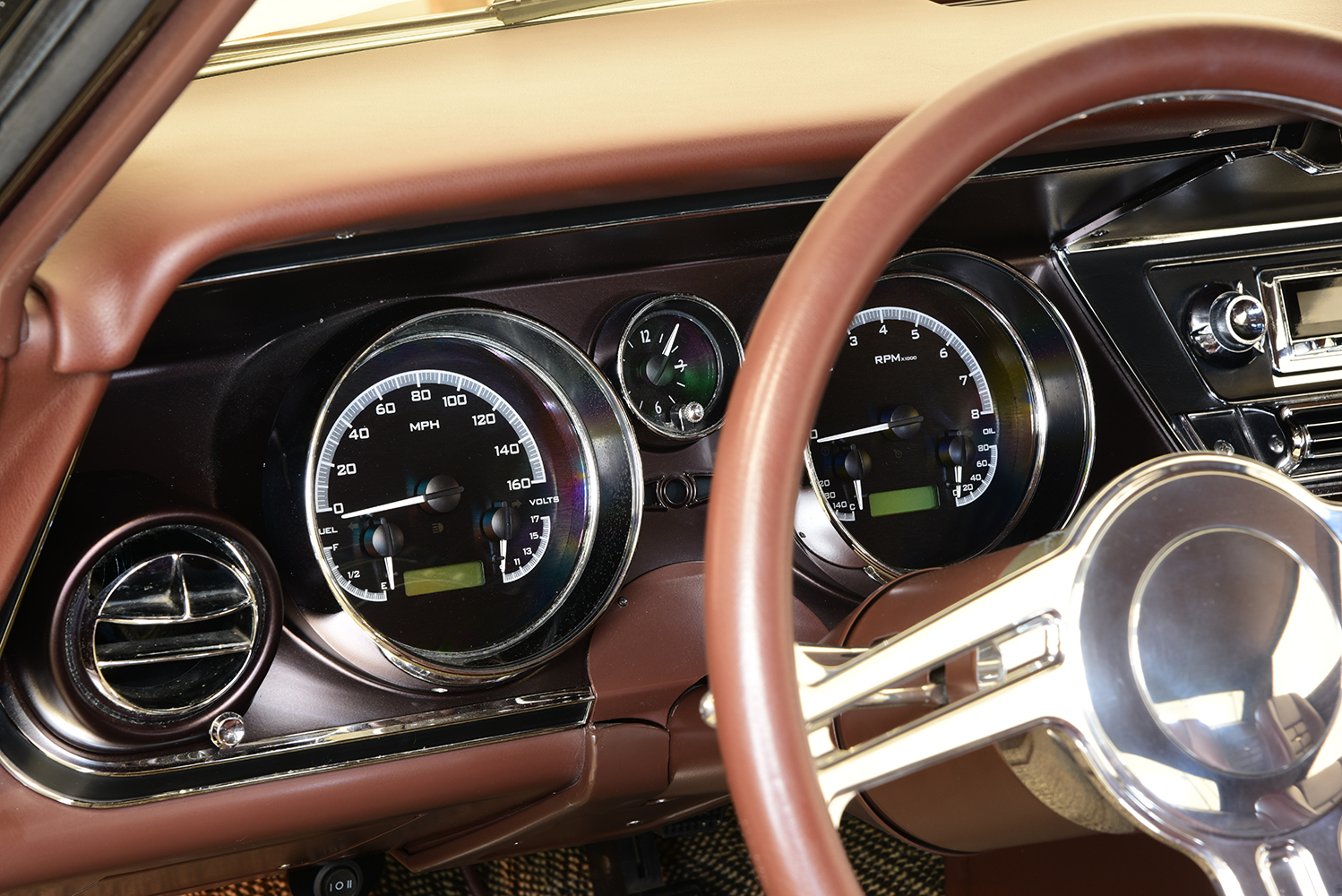 16 1963 Buick Riviera detailed view of Dakota Digital gauges behind a polished three spoke steering wheel