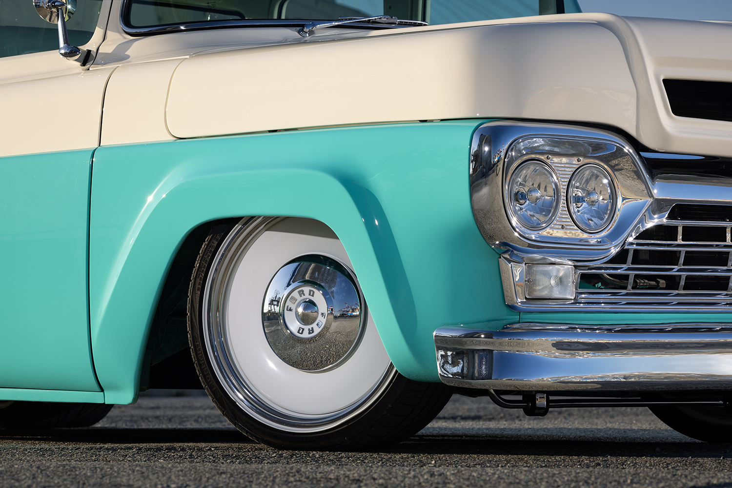 19 1960 Ford F 100 front fender close up with white steel wheels and chrome hubcaps