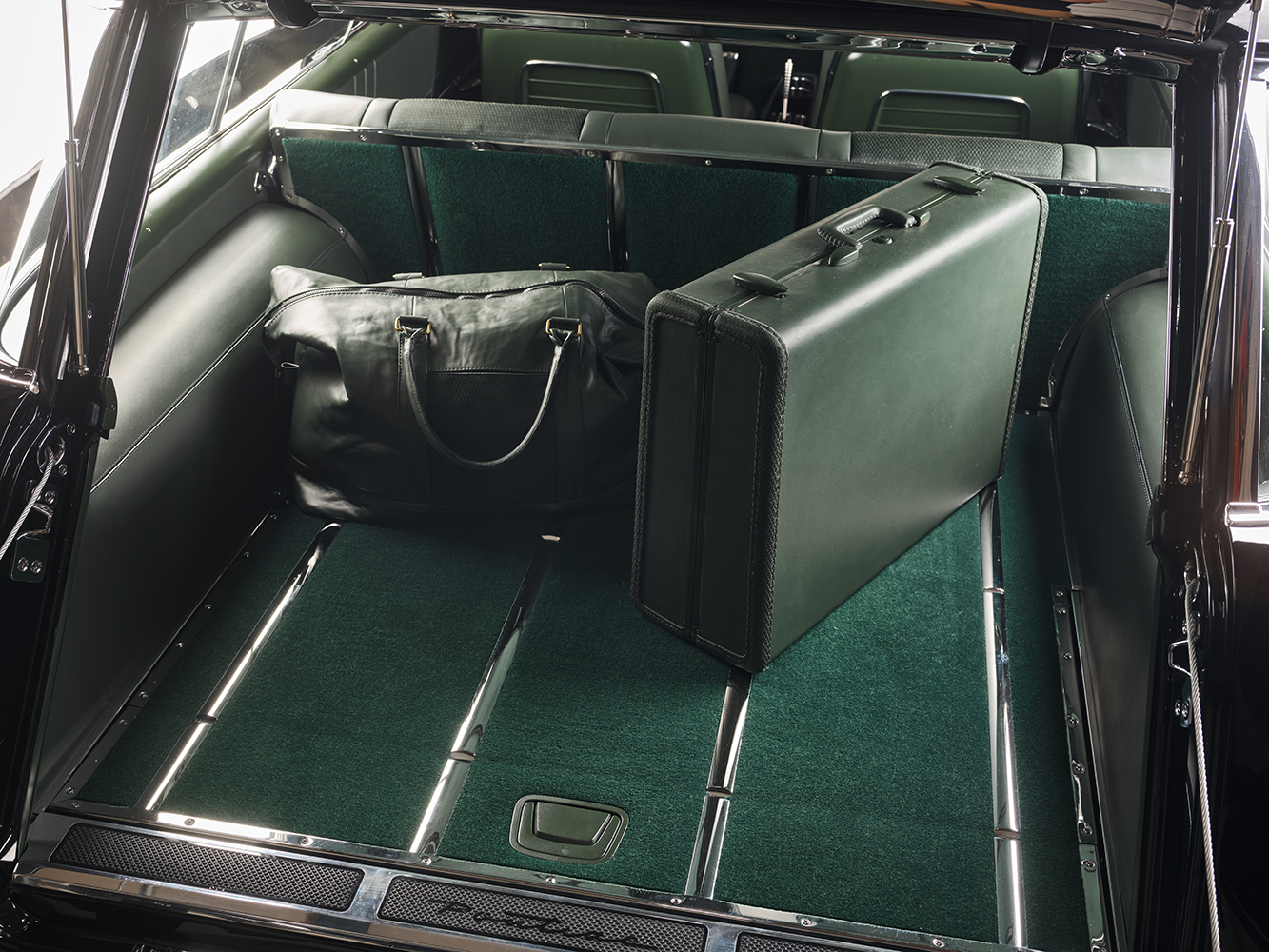 21 1957 Pontiac Safari wagon cargo area with green carpet fold down rear seats and matching vintage luggage set