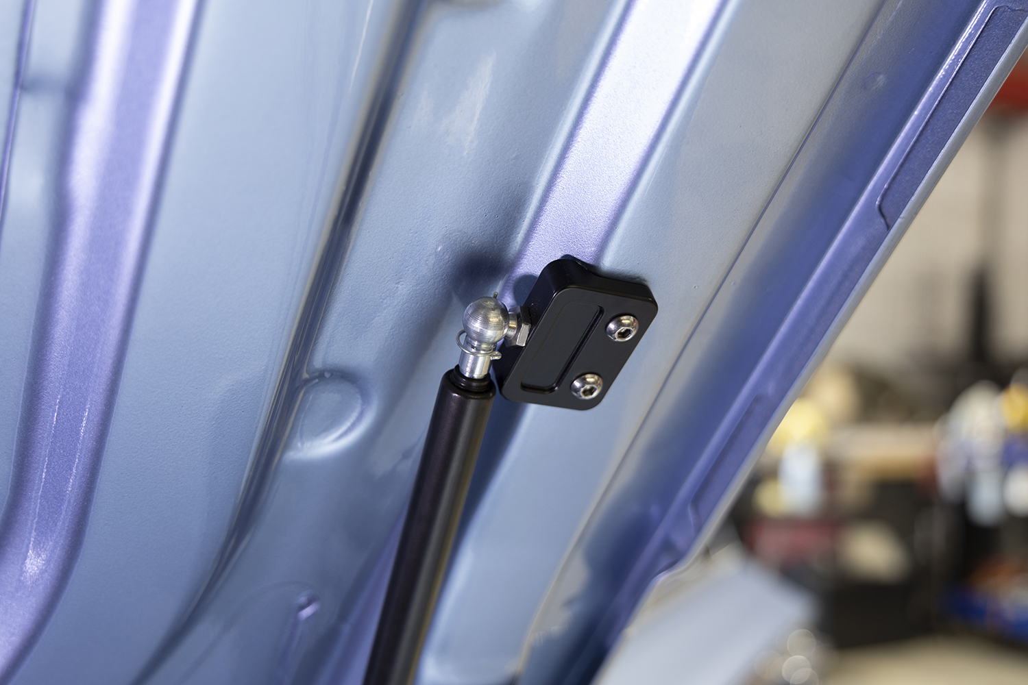 22 Black anodized gas strut bracket mounted to a 1962 Chevy Impala trunk lid