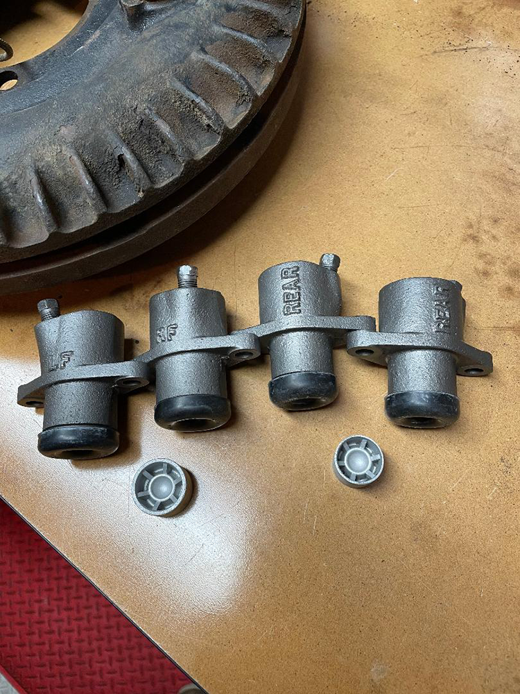 26 Vintage wheel cylinders with finned brake drum in background