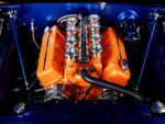006 1966 Chevrolet Nova engine bay with a high performance orange big block V8 and velocity stacks