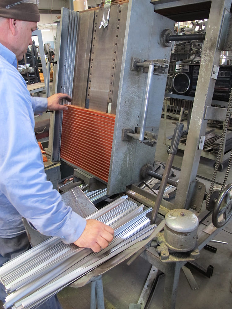 006 Worker assembling copper radiator cores in a manufacturing facility