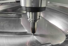 01 A CNC mill precisely cuts a contoured die for shaping classic fender panels