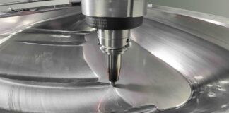 01 A CNC mill precisely cuts a contoured die for shaping classic fender panels