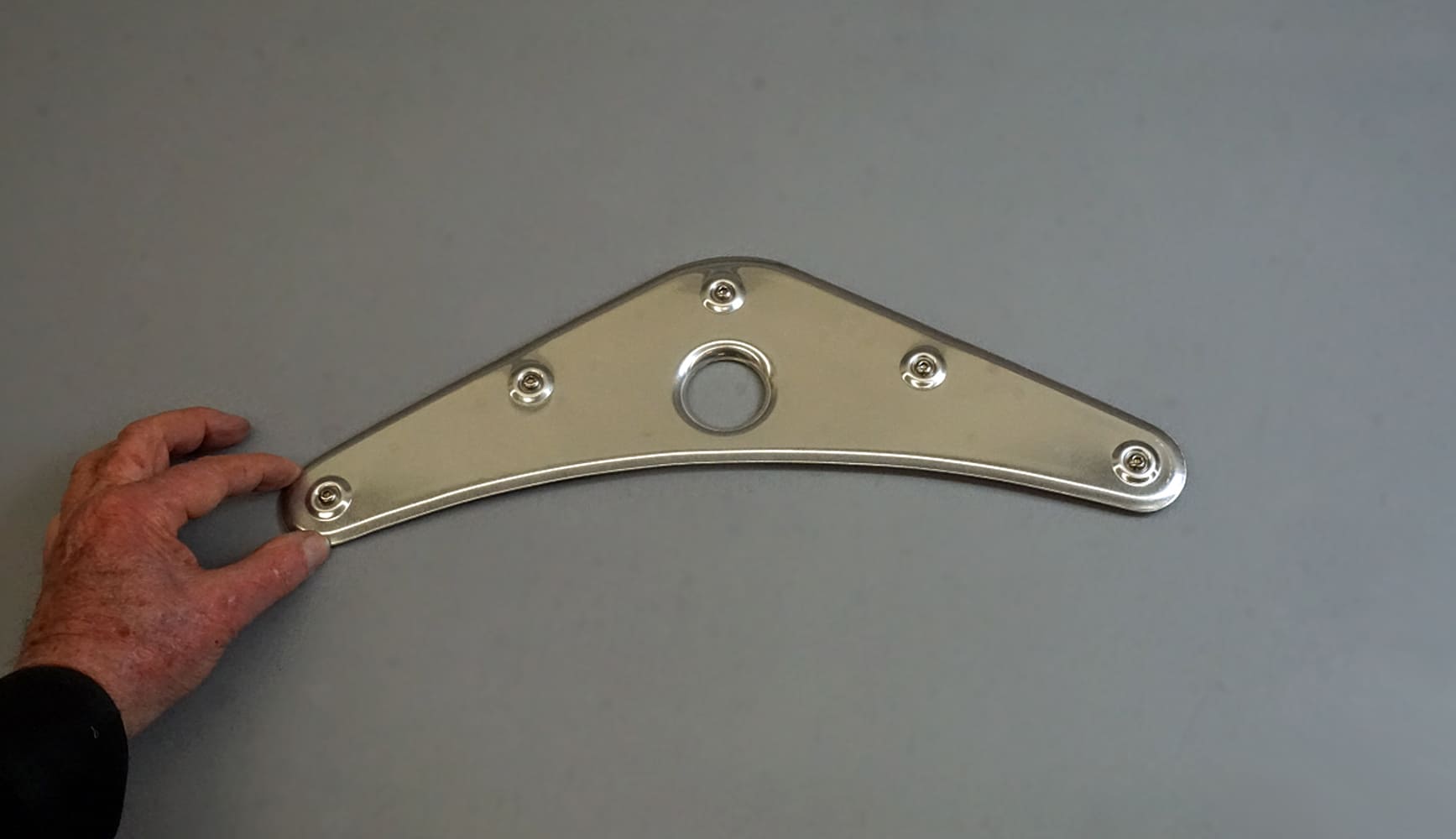 01 A polished aluminum bracket with multiple formed dimples for strength and aesthetics
