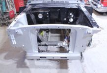 01 Ford Mustang core support with bare engine bay and fresh primer showcasing steering rack and chassis rails