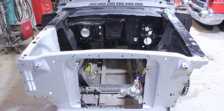 01 Ford Mustang core support with bare engine bay and fresh primer showcasing steering rack and chassis rails