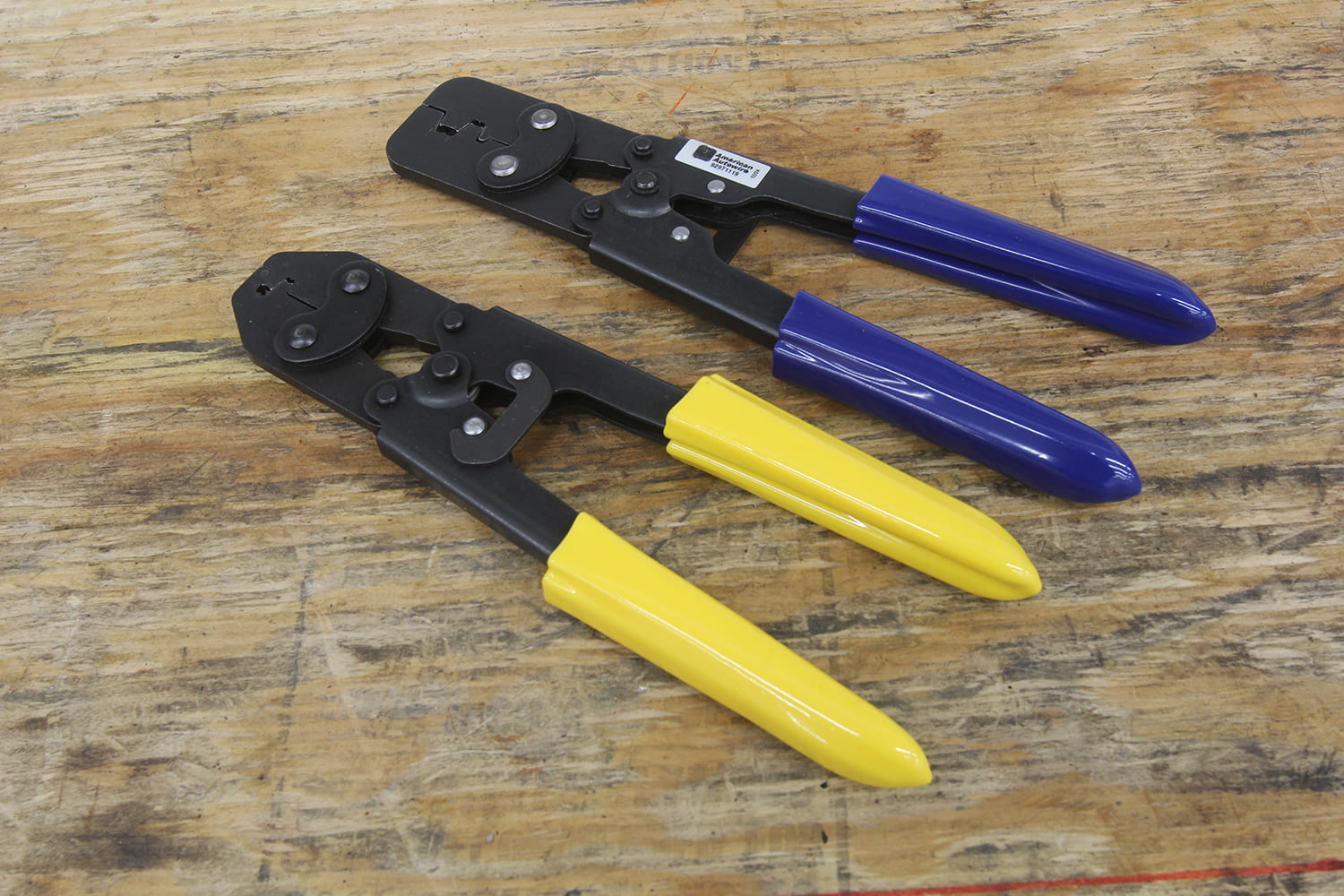 011 Pair of professional grade crimping tools with yellow and blue handles for electrical work