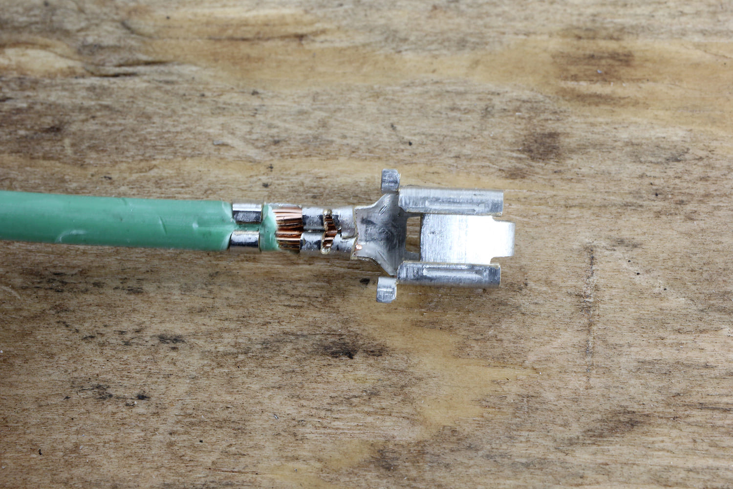 012 Poorly crimped green wire connection with exposed copper strands needing correction