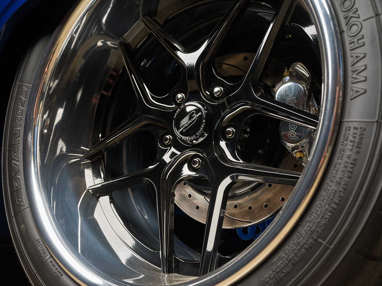 016 1966 Chevrolet Nova close up of multi spoke black and chrome wheels with Wilwood disc brakes