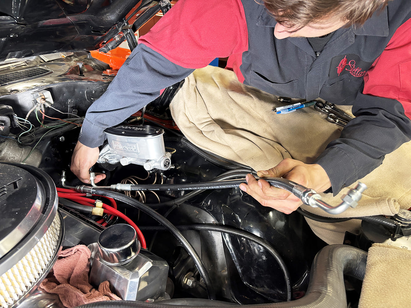 018 Mechanic routing new power steering hoses in the engine bay