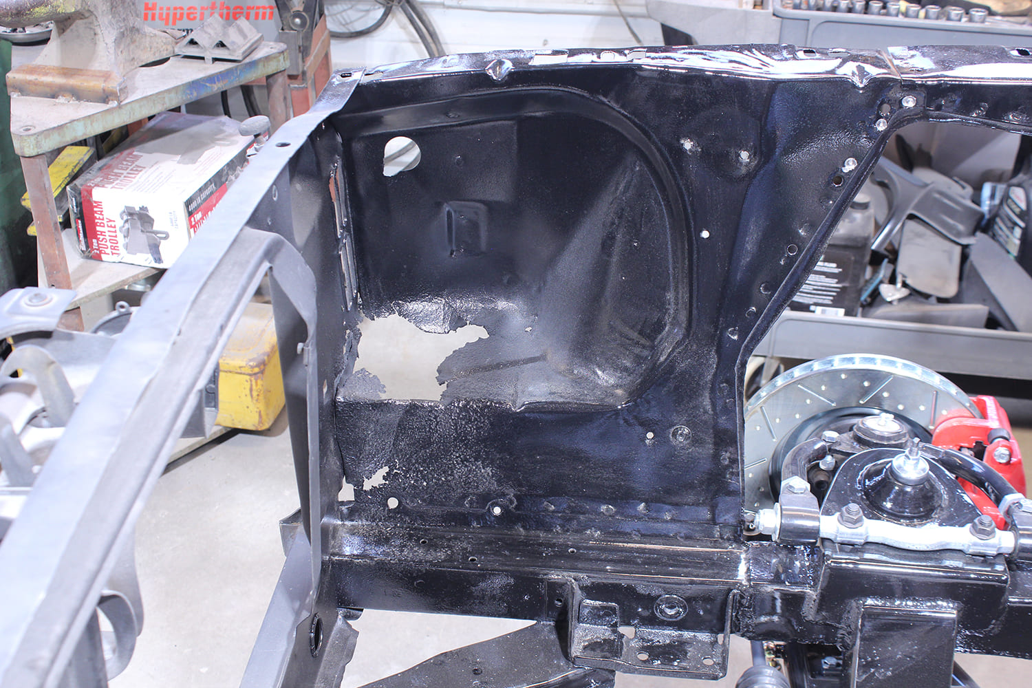 02 Passenger side apron of Ford Mustang with flaking undercoating and visible firewall panel contours