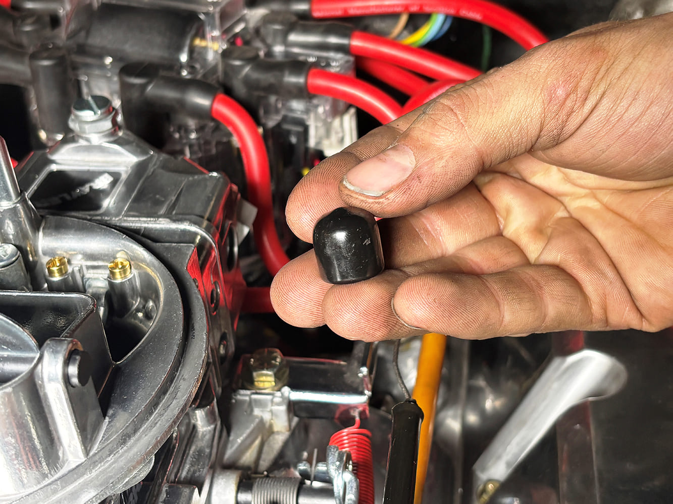 020 Vacuum port cap being prepared for installation on a carburetor