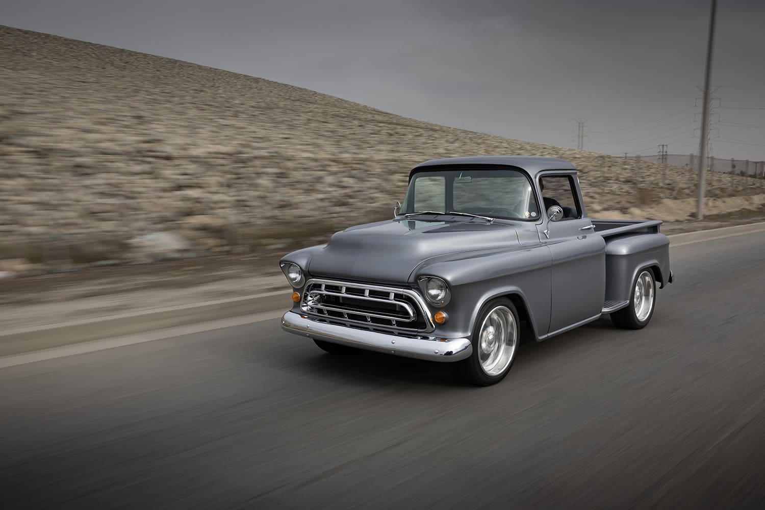 03 1957 Chevrolet Task Force pickup rolling shot with lowered stance and polished wheels