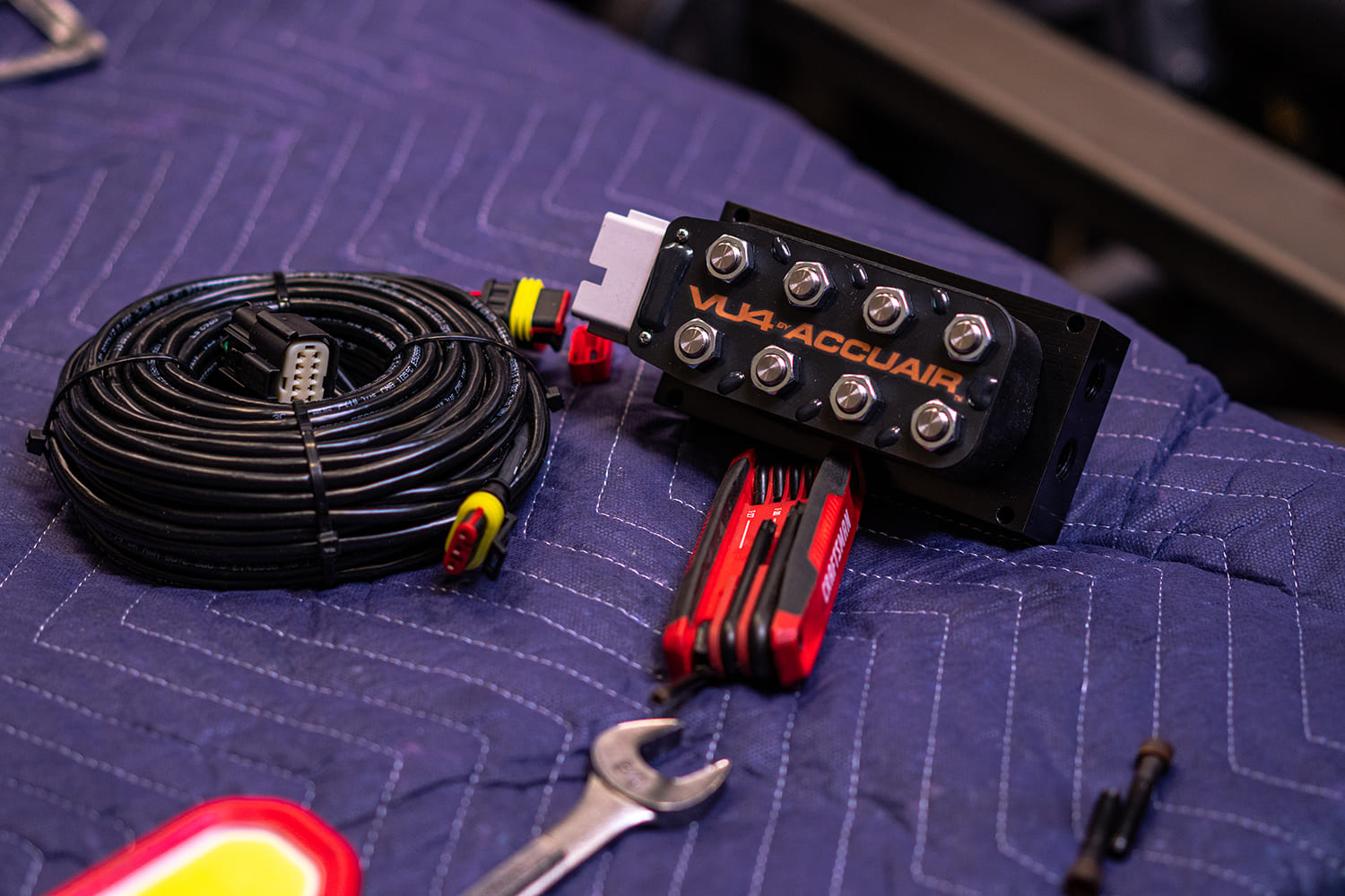 04 AccuAir VU4 valve block with wiring harness Craftsman hex key set and wrench on padded surface