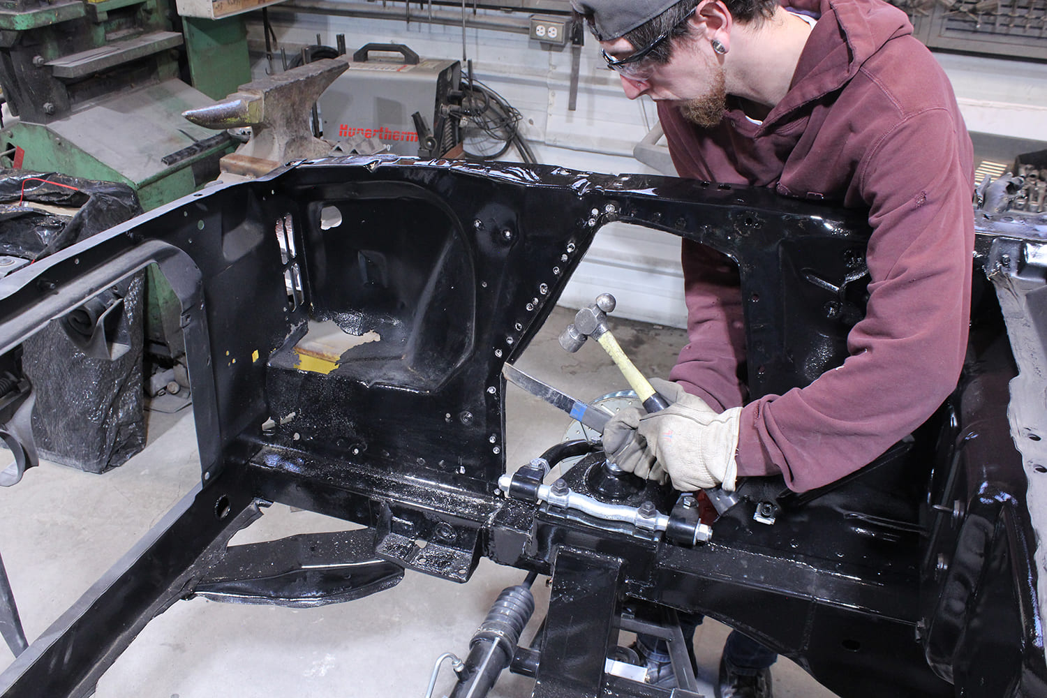 05 Technician chiseling spot welds from Ford Mustang apron near coilover and upper control arm mount