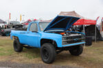 08 1985 Chevrolet K10 Squarebody with a lifted stance blue paint and Black Widow Exhaust branding