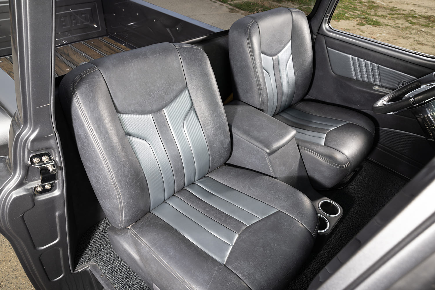 10 1957 Chevy truck interior with custom gray bucket seats and center console cupholders