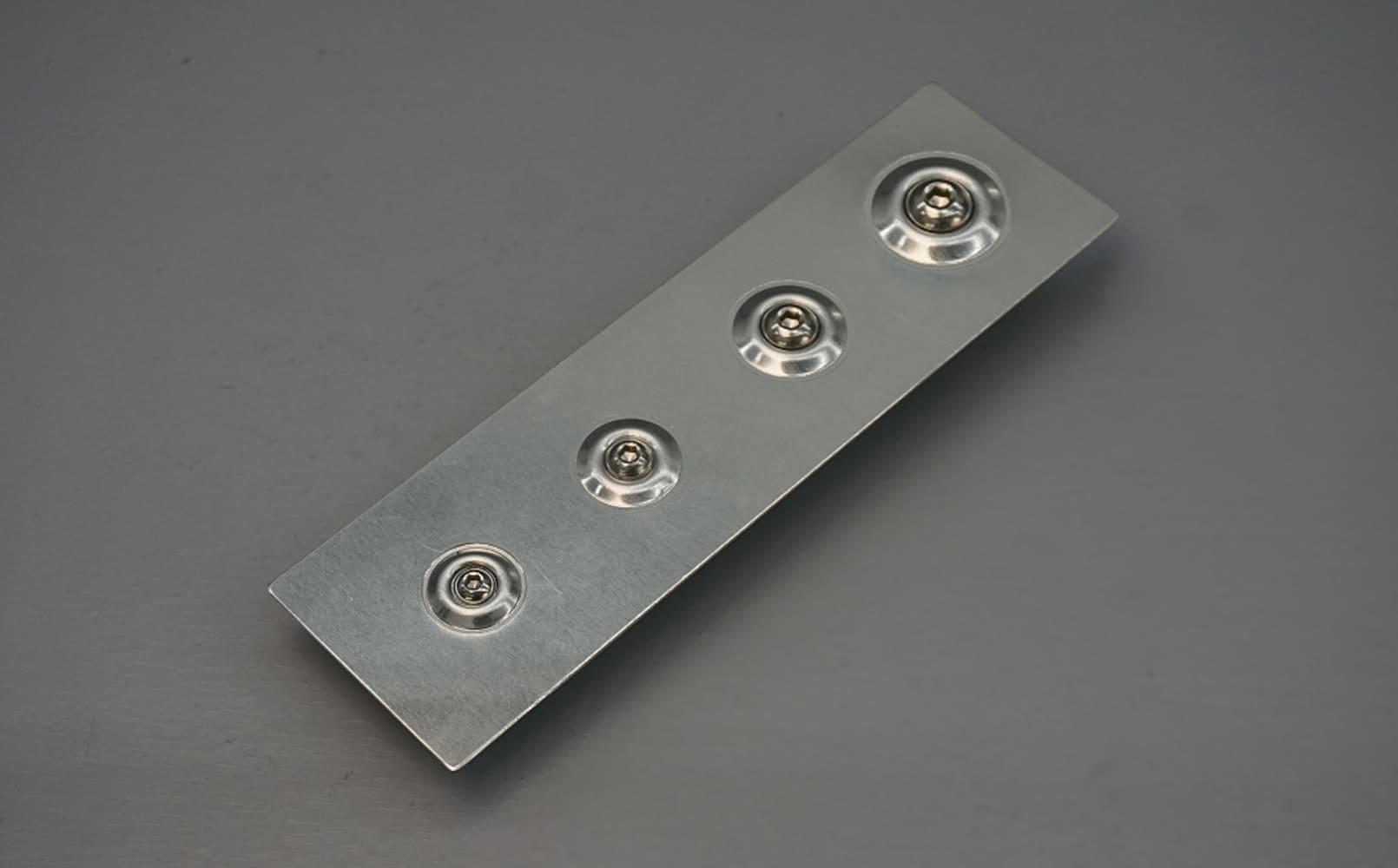 13 Close up of a completed dimpled metal panel with symmetrical hole reinforcements