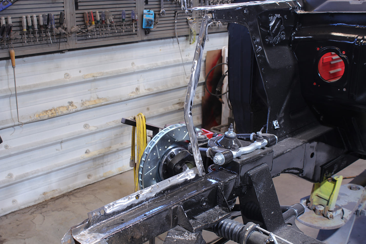 13 Close up of driver side rail and apron mounting area with drilled spot welds and disc brake system