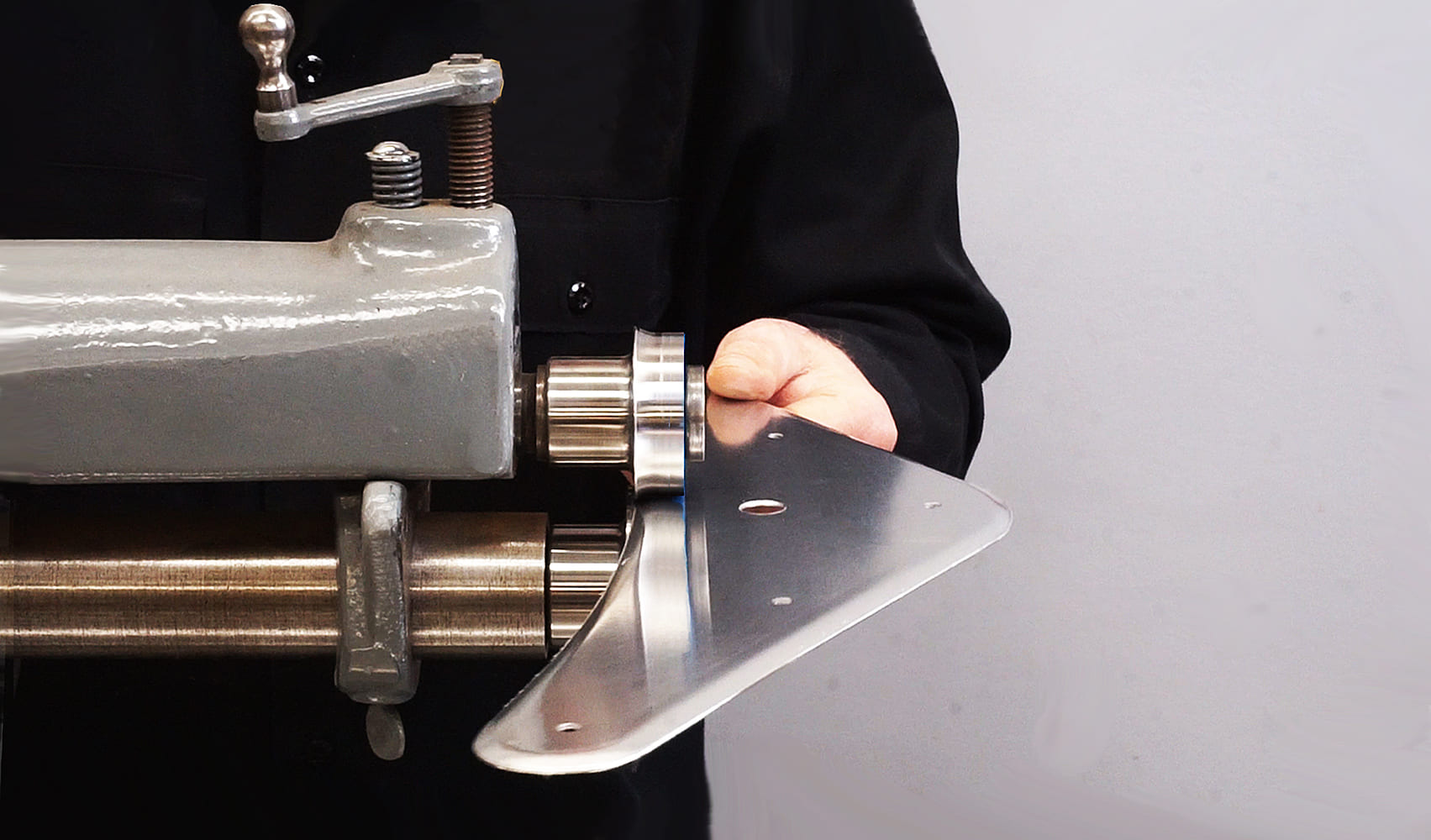 15 Worker using a bead roller to add structure to an aluminum panel