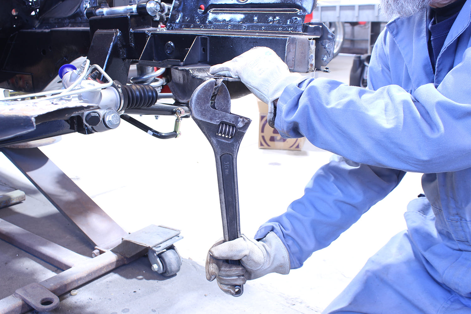 16 Straightening lower rail bracket on Mustang chassis with large adjustable wrench for alignment