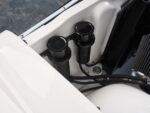 16 Twin black aluminum reservoirs mounted near radiator for fluids in 1959 Impala s engine bay