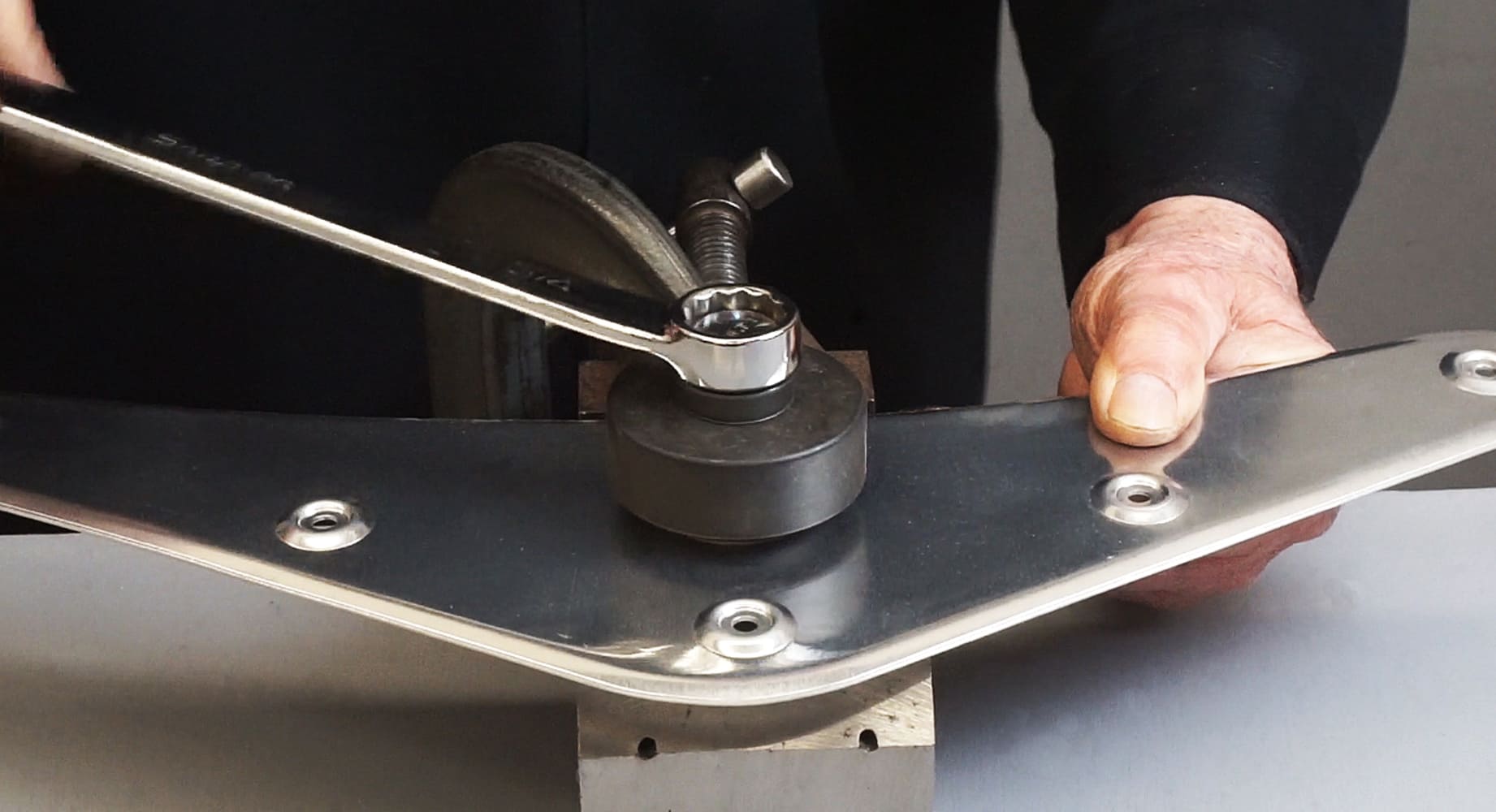 19 Technician using a manual press and die set to form precise dimples in an aluminum panel