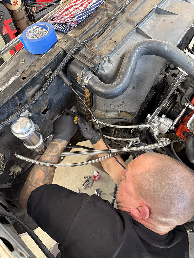 21 Tech routes braided steel lines through the engine bay firewall of a 1971 Chevy C10 for power steering setup