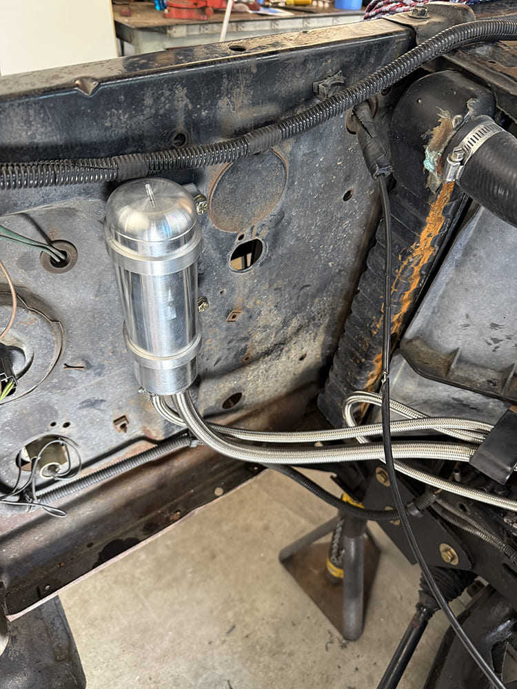 22 Polished aluminum remote reservoir mounted to firewall with braided hoses secured underneath