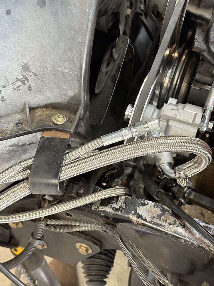 23 Braided AN lines cleanly routed from power steering pump to steering rack with tight clamp management