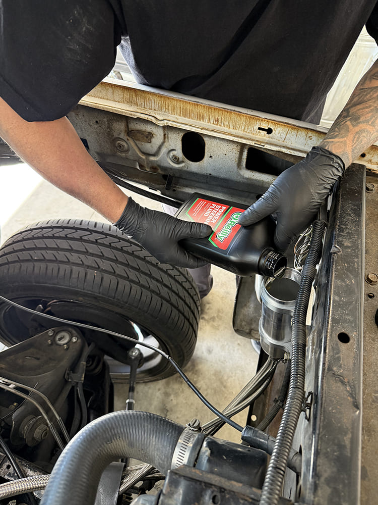 24 O’Reilly power steering fluid being poured into the remote reservoir during fill and bleed process