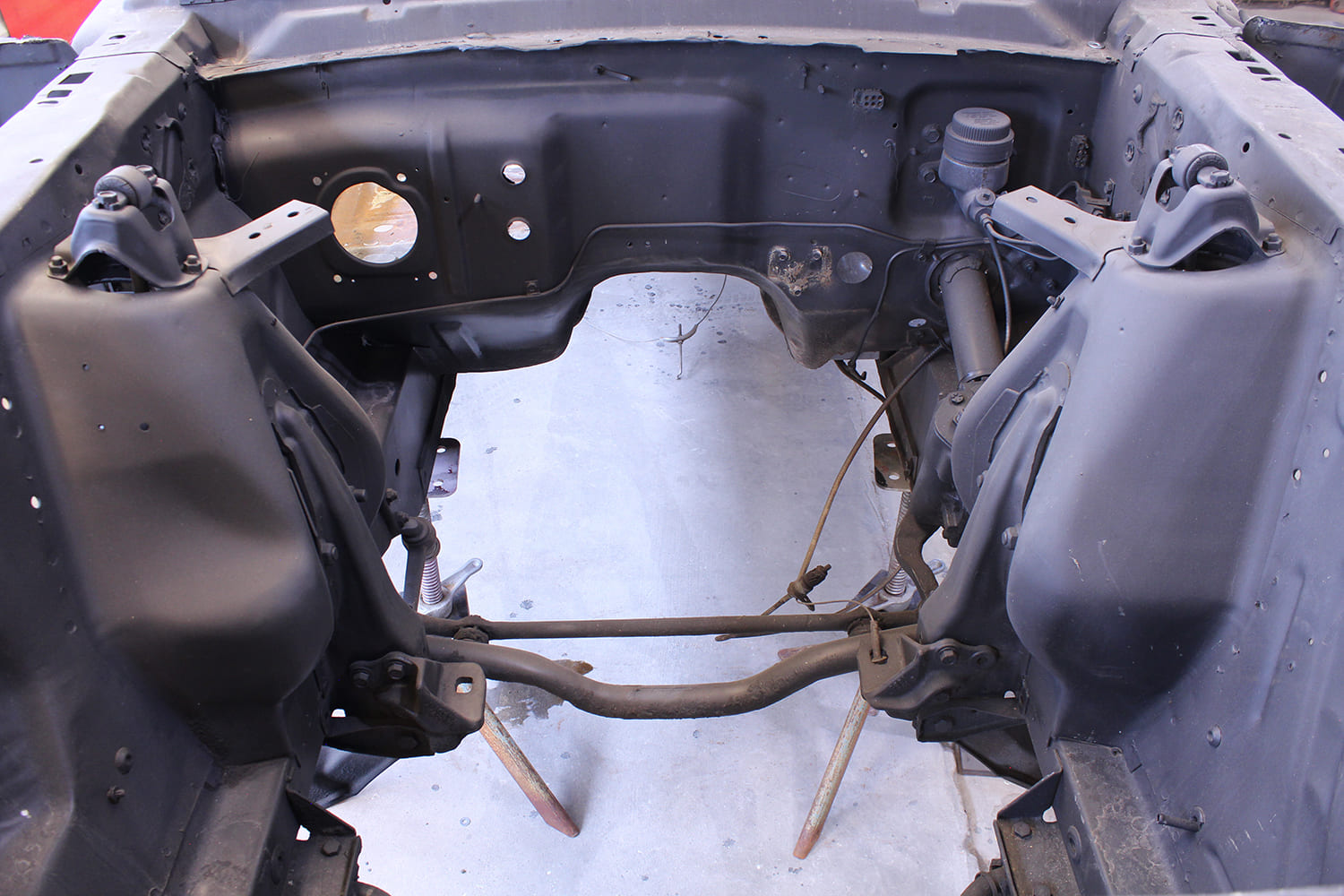 24 Original Mustang engine bay with factory suspension mounts and brake lines before restoration
