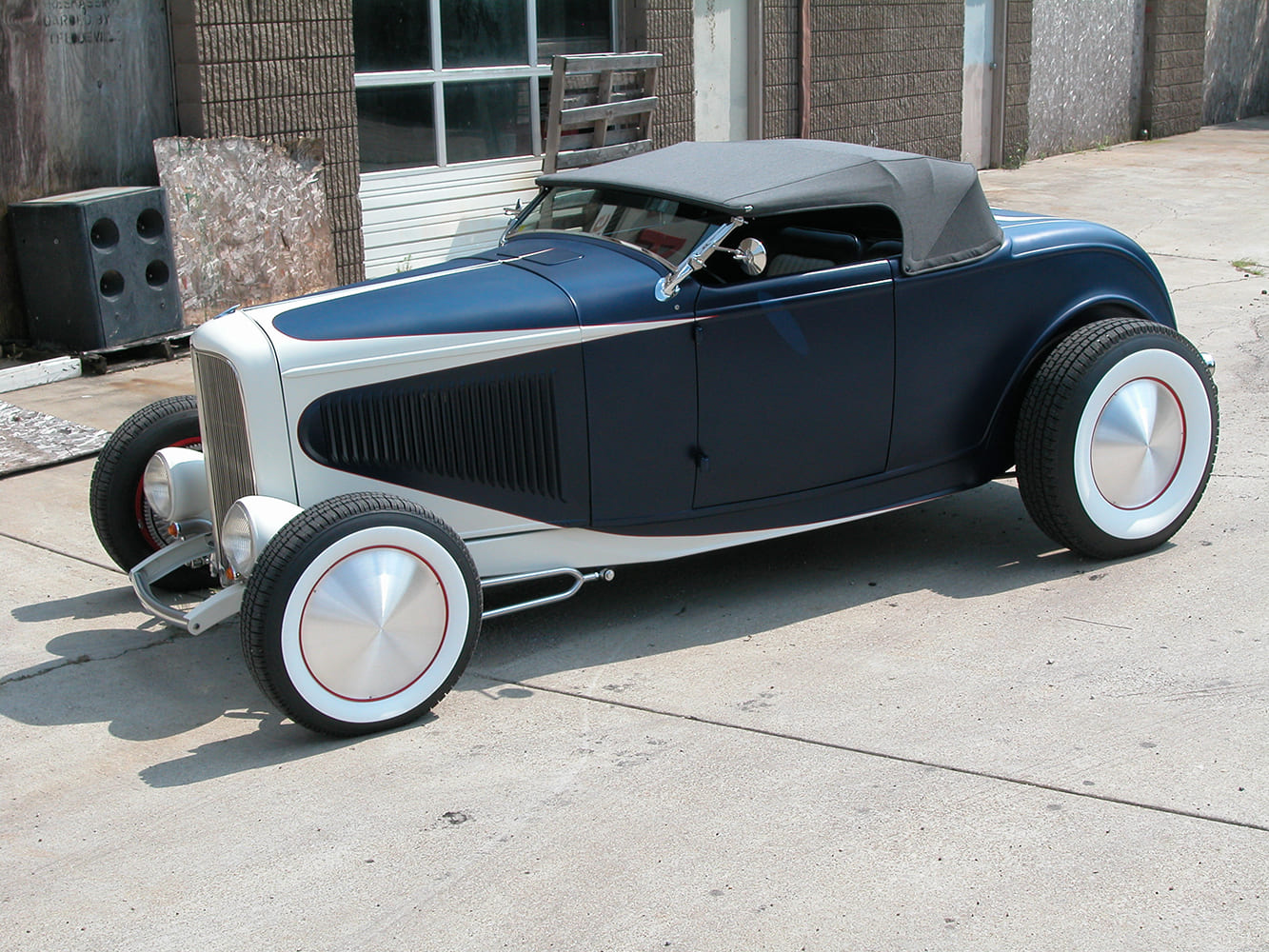 25 1932 Ford Roadster in two tone navy and pearl with custom hubcaps and gray convertible top