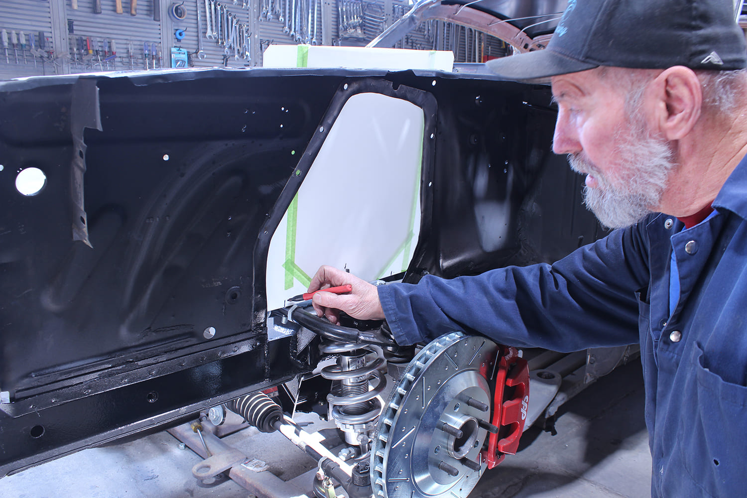 25 Technician marks template alignment on Mustang inner fender for custom patch fabrication