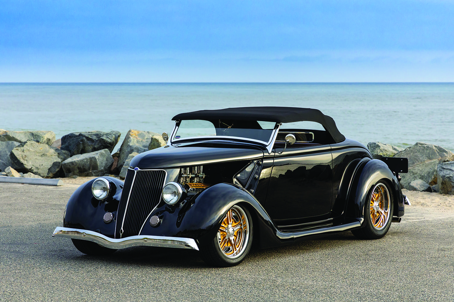 27 1936 Ford Cabriolet with black soft top gold billet wheels and lakeside backdrop