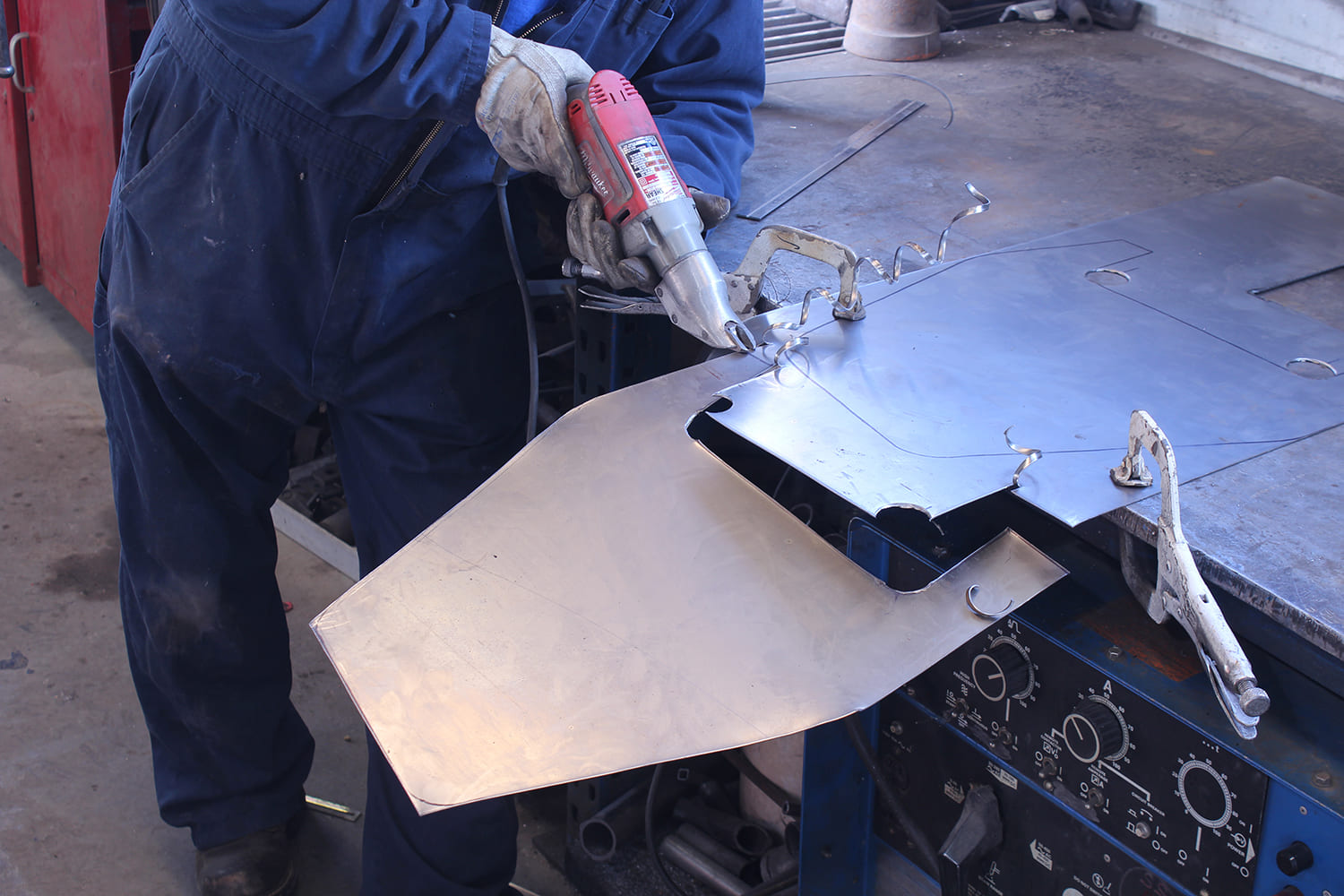 27 Cutting custom patch panel from sheet metal with air shear guided by traced template
