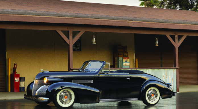 01 1939 Cadillac Convertible black with whitewalls and chrome trim parked under vintage gas station awning