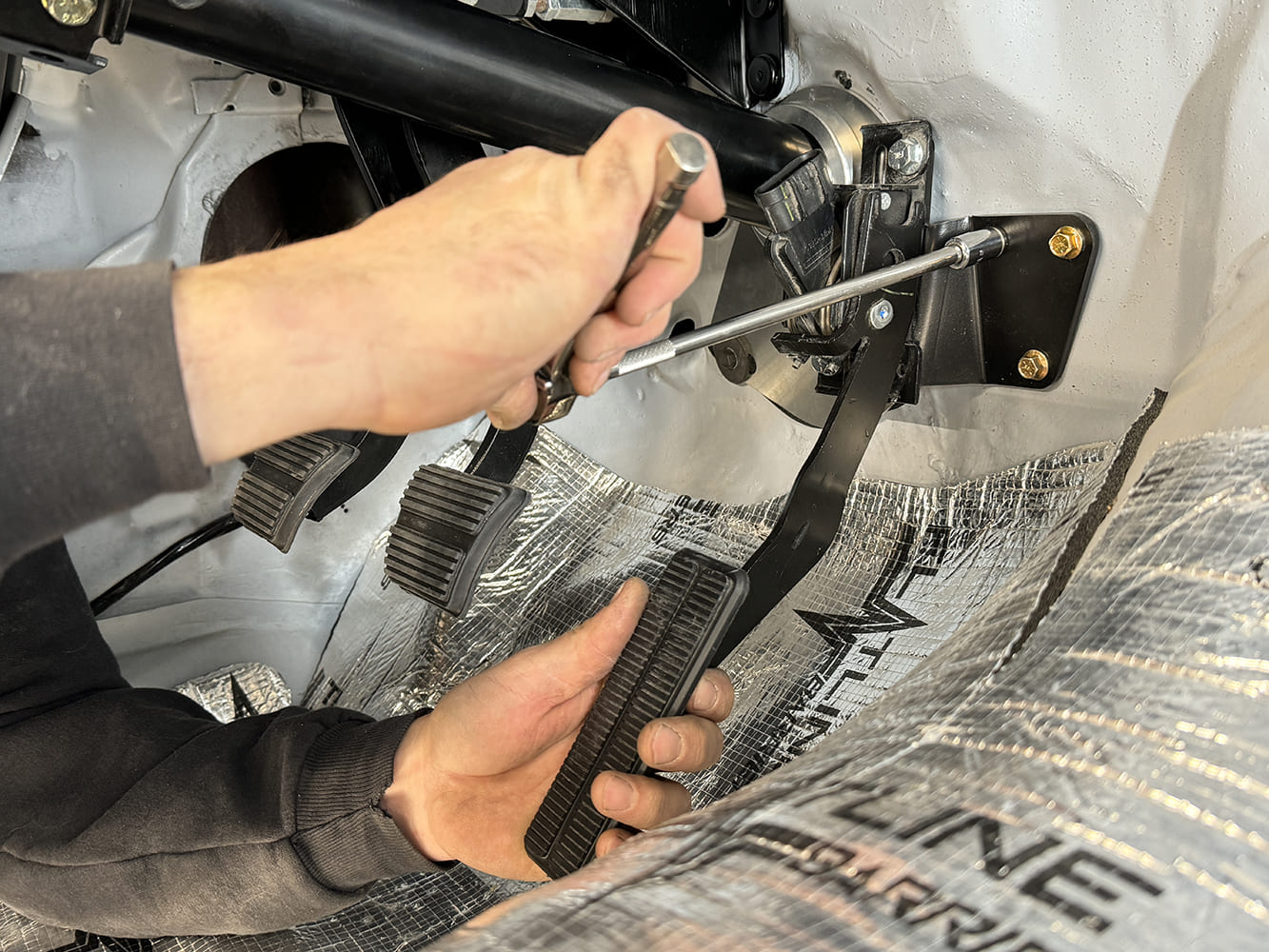 013 1971 Camaro throttle pedal bracket fastened to firewall support near steering column base