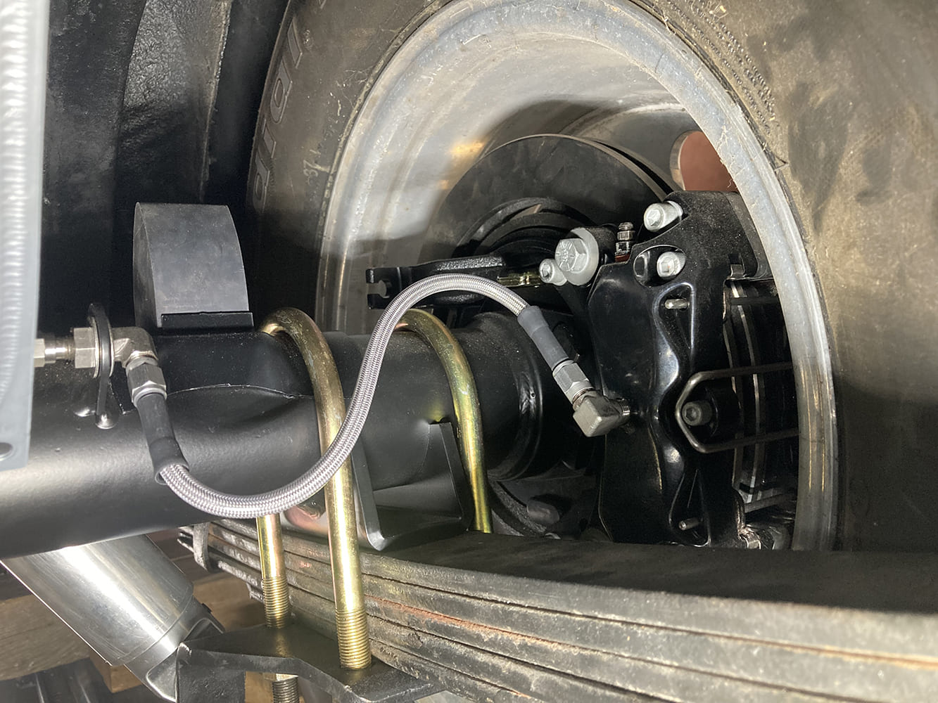 016 Close up of braided brake hose routed to caliper with AN fittings