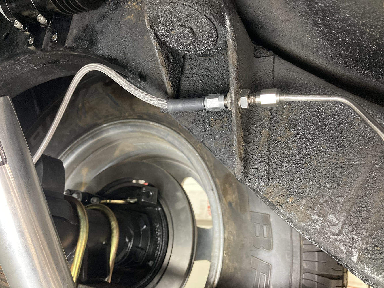 017 Rear brake line junction showing transition from braided to hard line