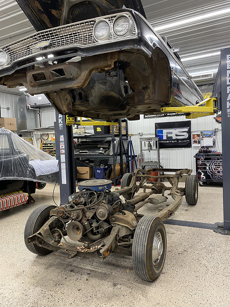 02 1963 Galaxie body lift revealing original chassis with V8 drivetrain and rust patina