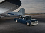 02 Poteet's 1960 Ford F 250 crew cab custom lowered blue and white truck beside vintage airplane