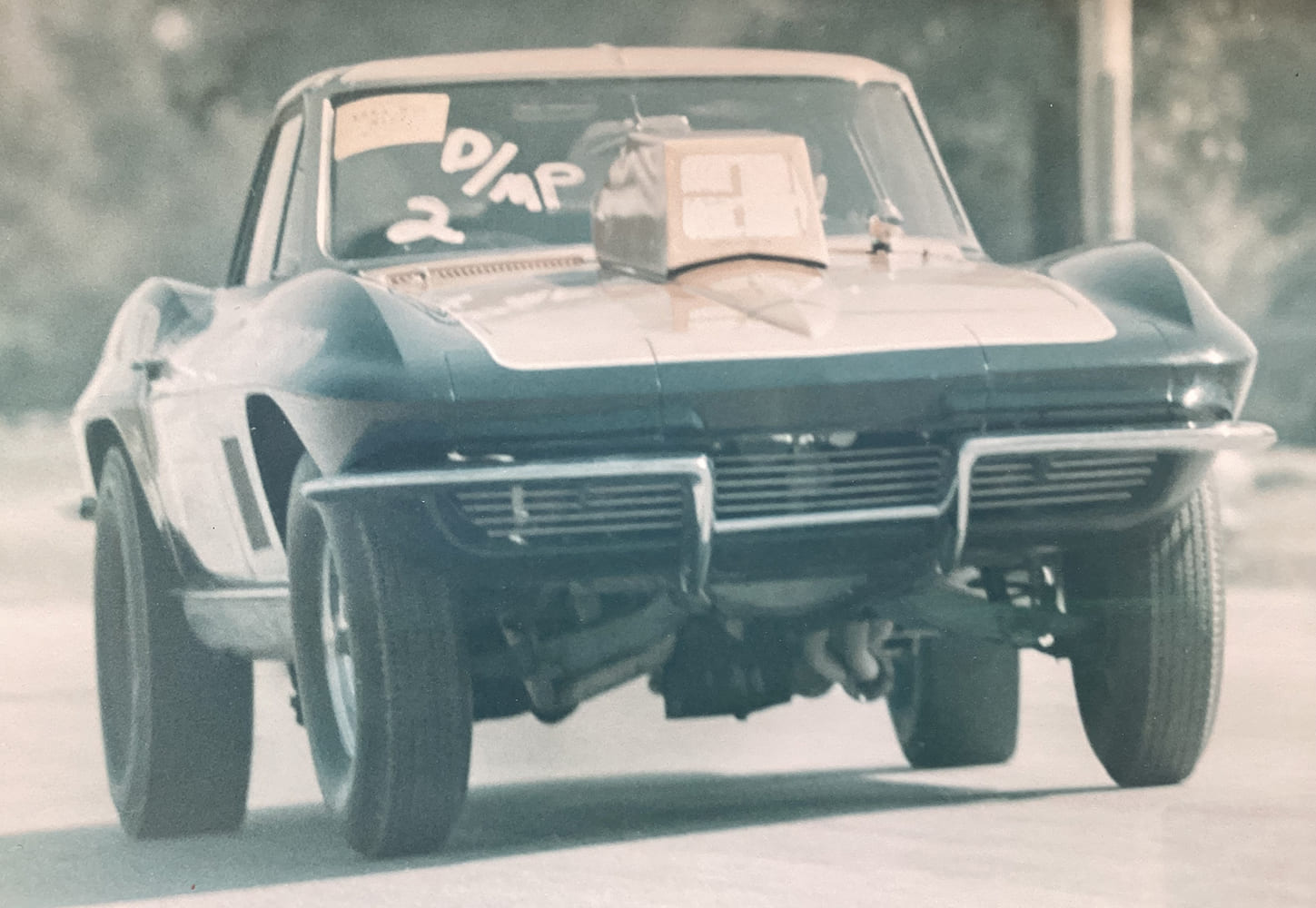020 Vintage photo of early 1960s drag spec Corvette launching hard with period hood scoop and raised front
